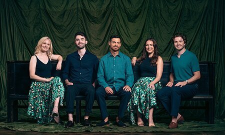 Apollo 5 Die fünf Sänger von Apollo 5 auf einer Bank.