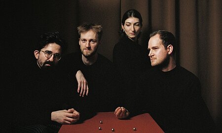 Sie sehen das Quatuor Agate in der aktuellen Besetzung an einem Tisch sitzen